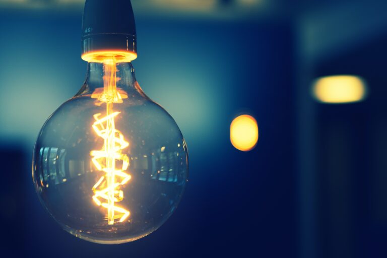 a round edison bulb glows suspended from the ceiling