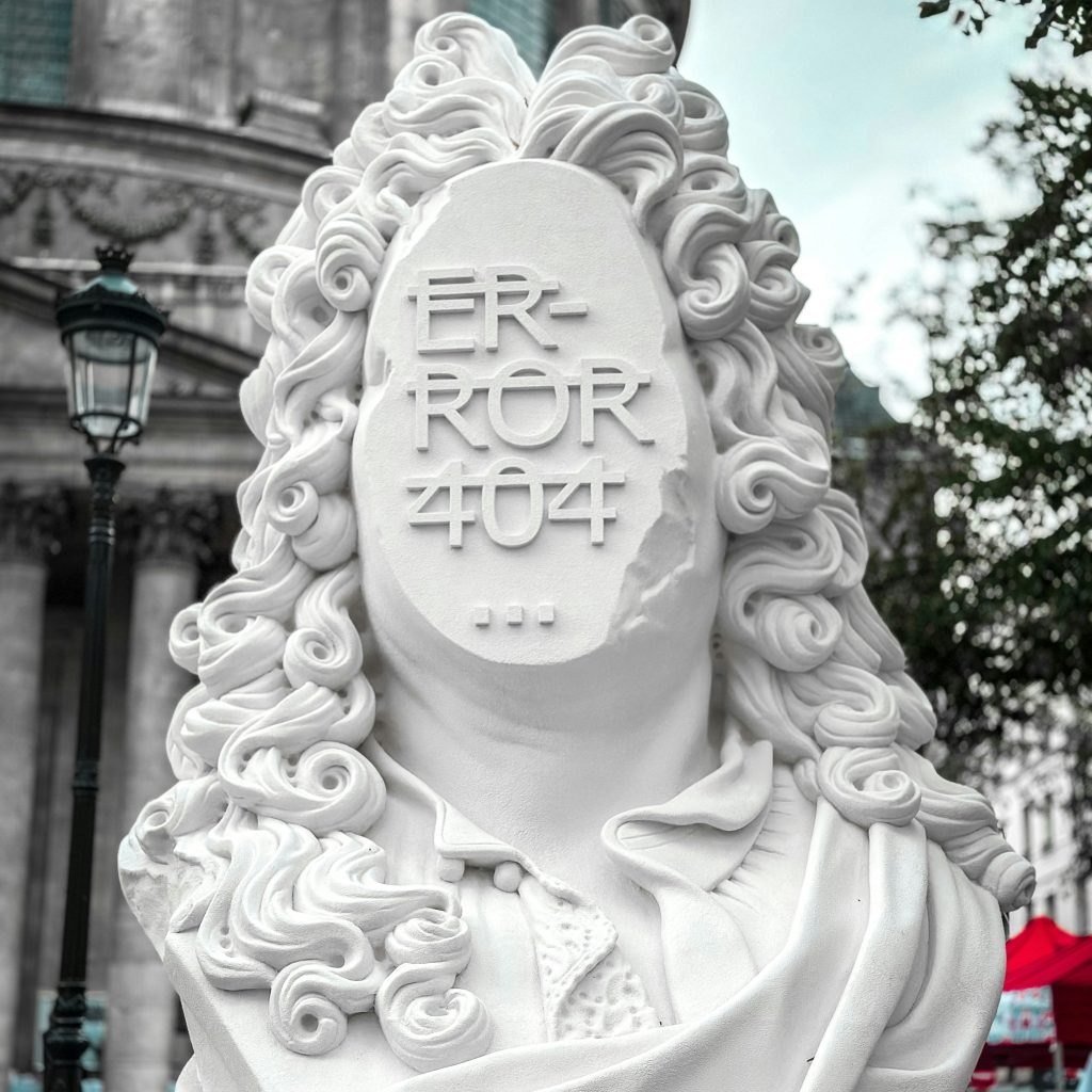 A statue (bust) with long curly hair but instead of a face it says "Error 404"
