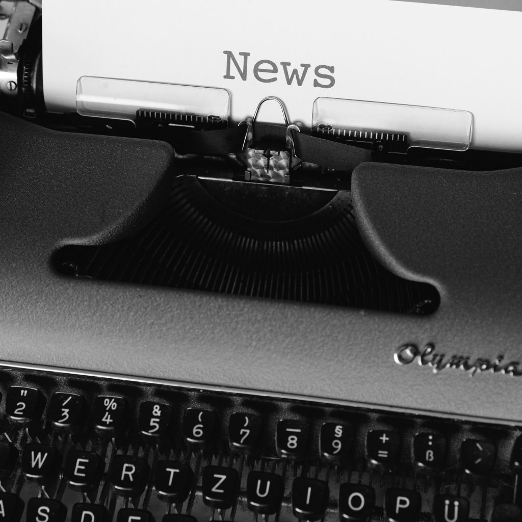A manual typewriter with the word "News" on the paper that was just typed